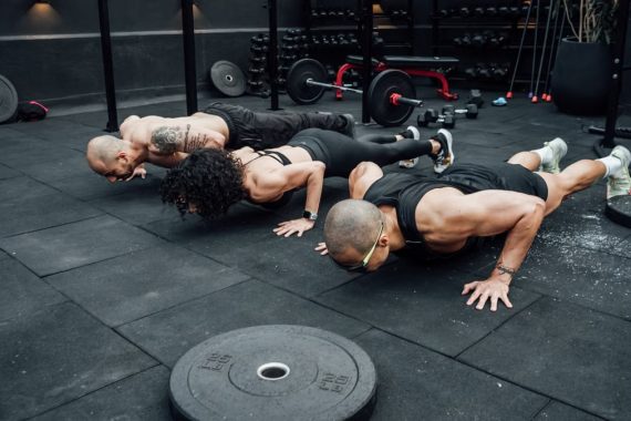 Fitness enthusiasts performing push-ups in a Mexico City gym. Emphasizing teamwork and strength.